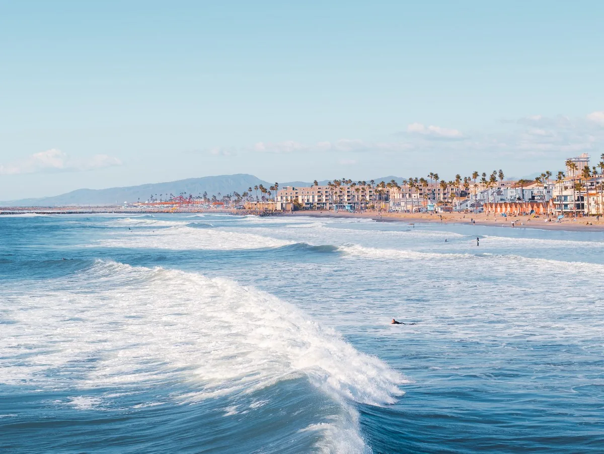 The Orange County coastline on a clear morning, with the beach town behind the break
