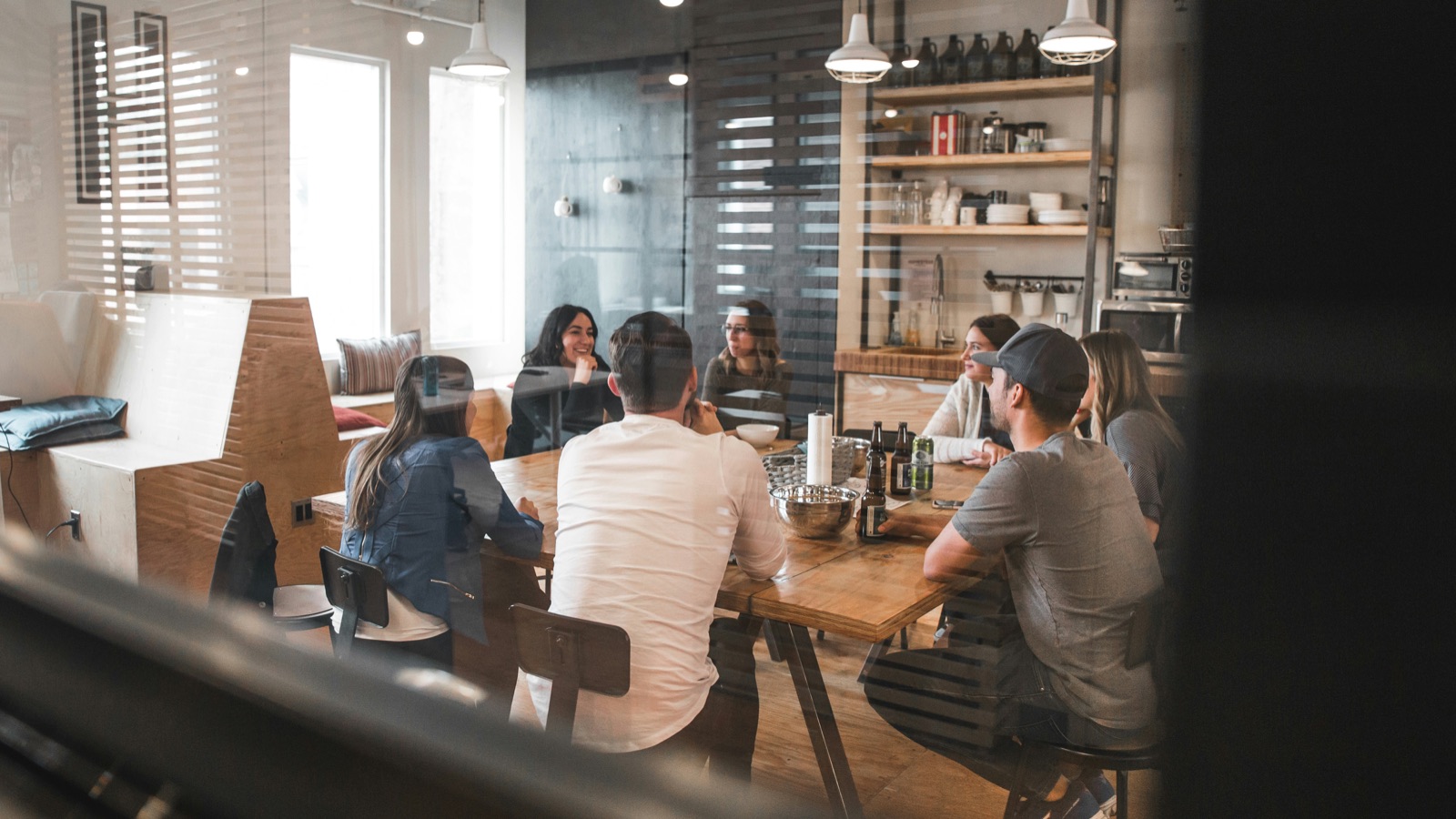 A marketing team meeting around a table, talking through strategy in the room together